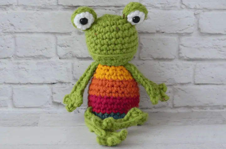 Crochet green frog with yellow, orange, red and blue striped body