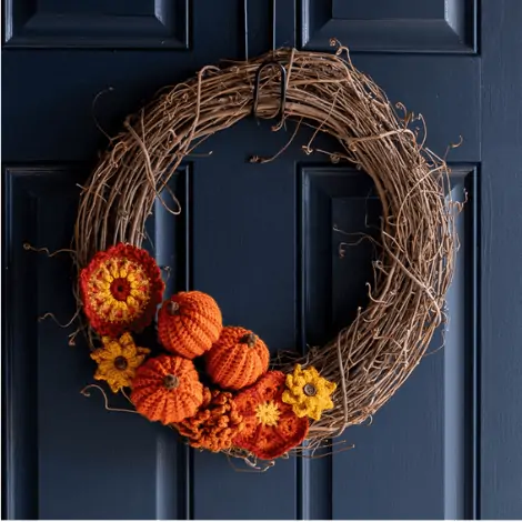 grapevine wreath with crochet pumpkins and flowers orange, yellow and gold
