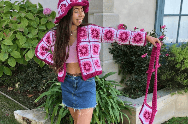 Granny Square Hardigan avec une variété de fils roses.