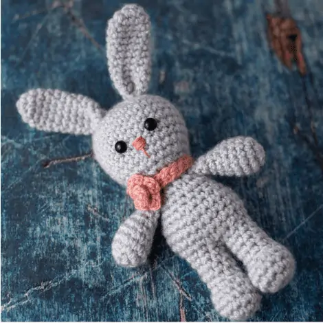 gray crochet bunny with pink floral necklace