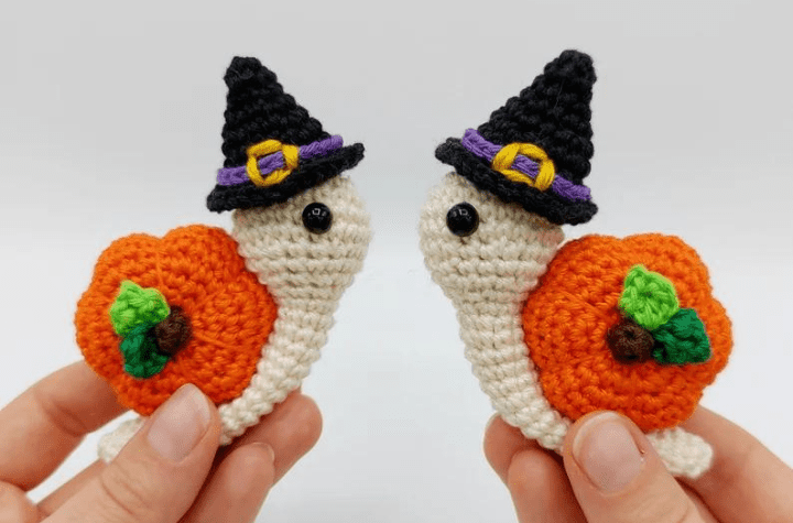 Two little snails with witch hats and pumpkin shells.