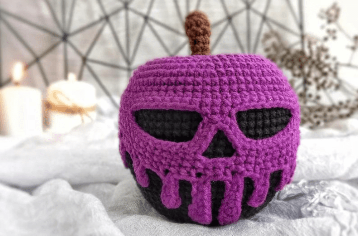 A black apple with purple skull-shaped poision.