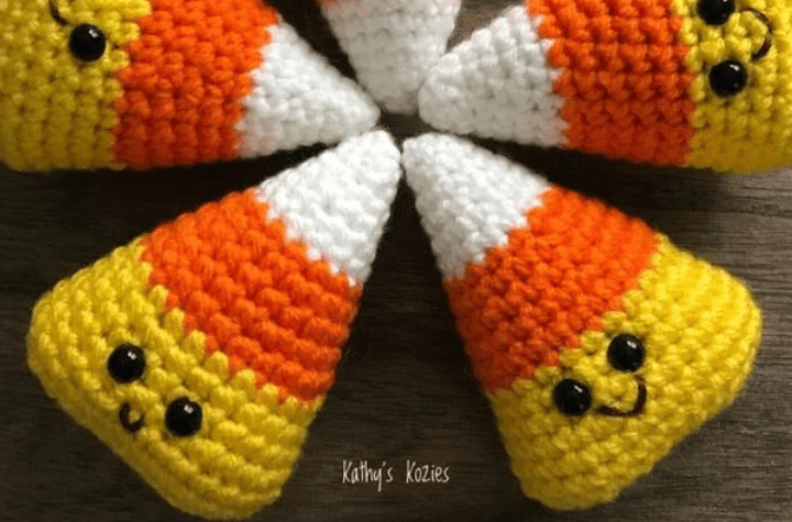 Five candy corn stuffies with little smiley faces.