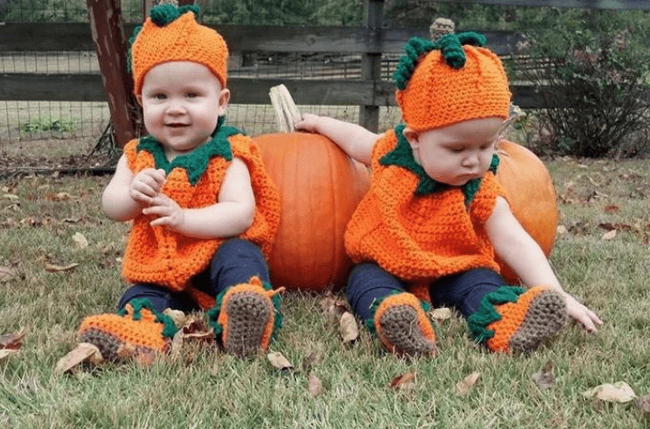 Crochet pumpkin outfits on two toddlers.
