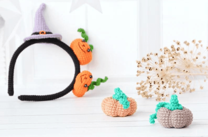Headband with a witch hat and two little pumpkins.