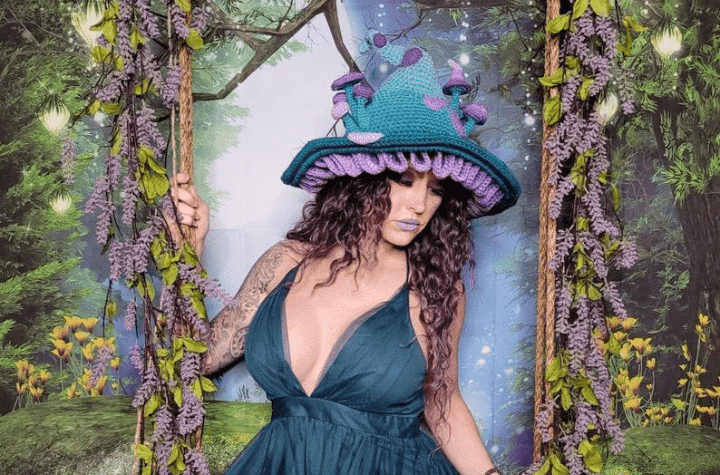 fairy garden witch hat with blue and purple mushrooms sticking out from the hat.