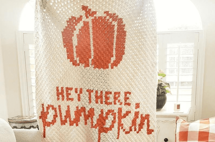 crocheted pumpkin blanket that says "hey there pumpokin"