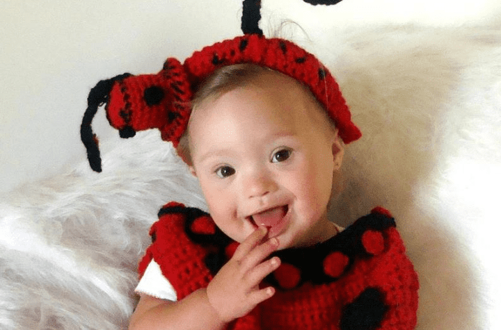 Little girl wearing a crochet ladybug costume.