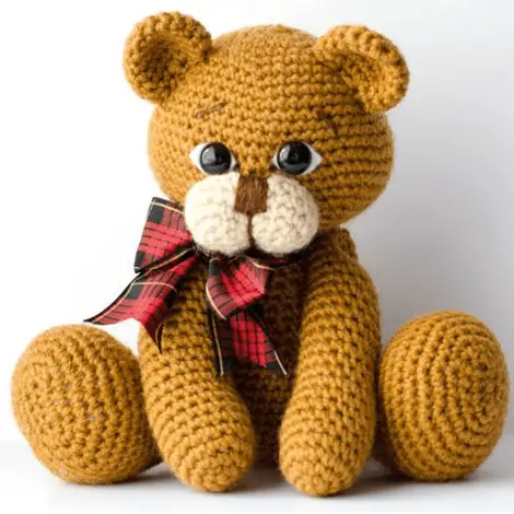 brown crochet bear with red plaid bow