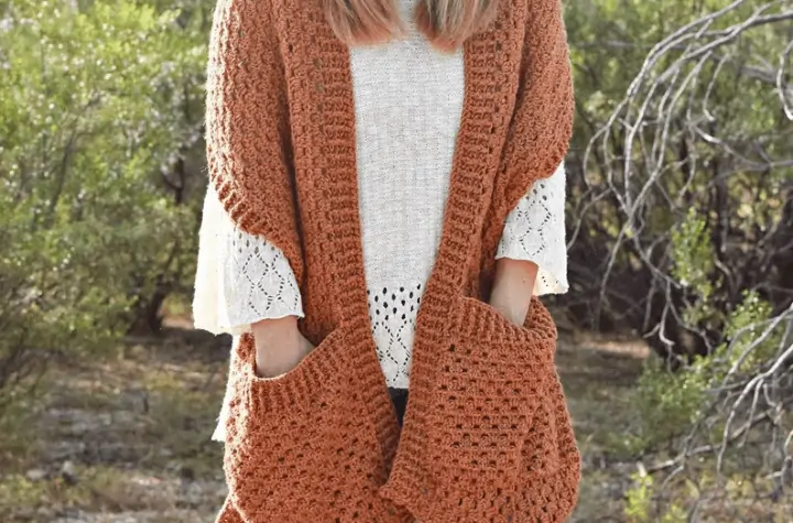 orange crochet shawl with large pockets.