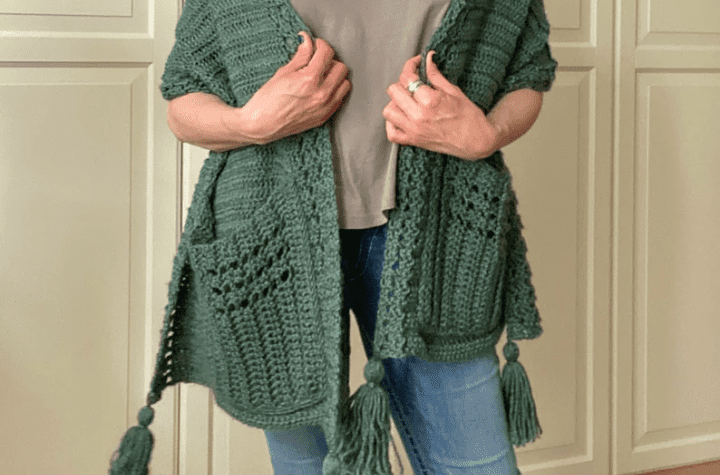 Green pocket shawl with tassels at the bottom.