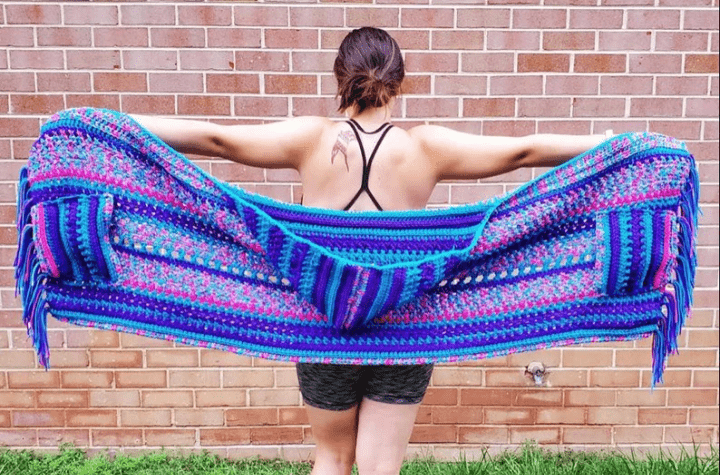 Colorful hooded crochet shawl with pockets.