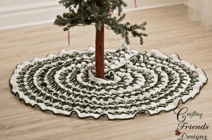 Small tree with a green and white circular tree skirt.