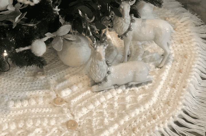 All white tree skirt with little deer statues on it.