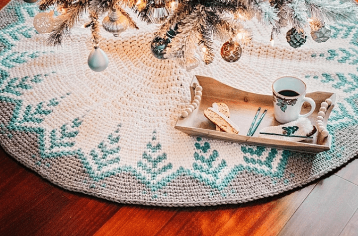 A mostly white tree skirt with green and grey accent colors.