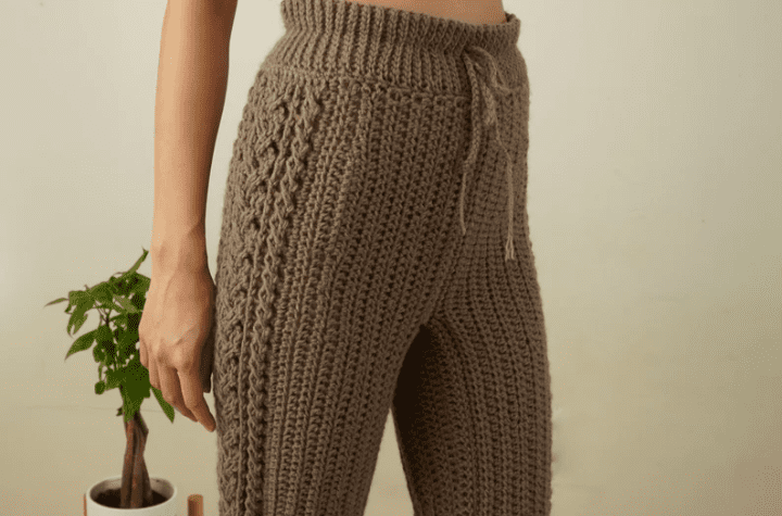 Brown crochet pants with cable detailing along the side seam.