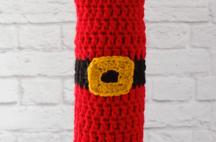 Santa-inpired wine cozy. All red with a gold buckle in the middle.