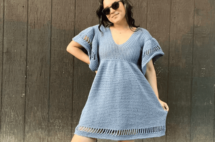 Short sleeve blue crochet dress with stitch gaps along the border of the dress.