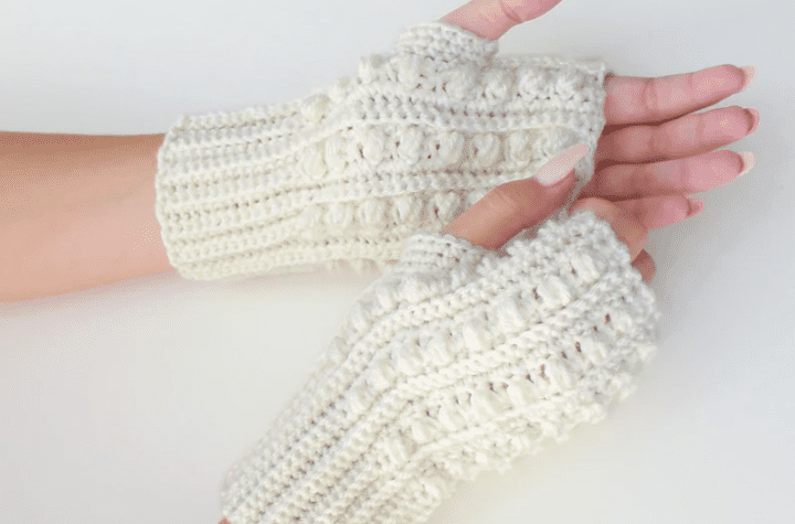 White fingerless gloves with pearl-looking stitches.