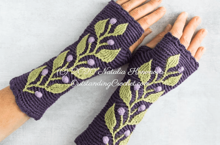 Fingerless gloves with a branch of leaves that run fully along the top of the gloves.