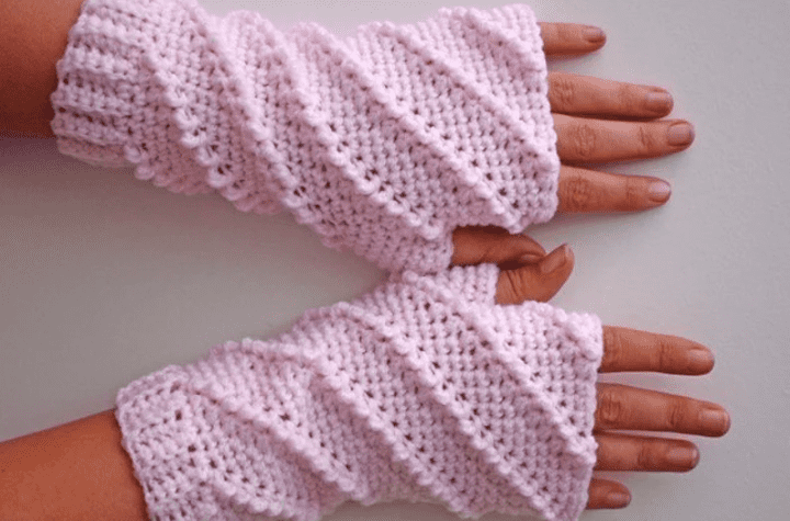Pink fingerless gloves with swirled stitching.