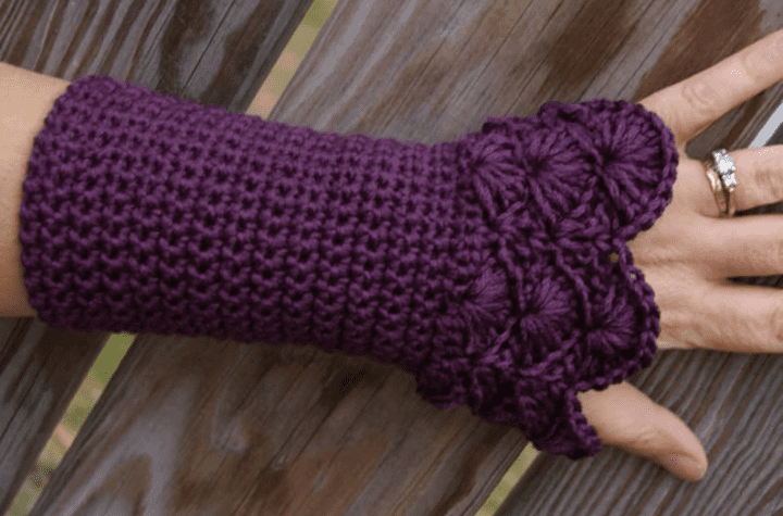 Purple crochet fingerless gloves with decorative stitching from the wrist up.