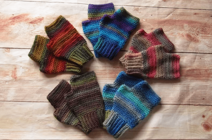 Five pairs of crochet fingerless gloves using gradient yarn in different colors. different