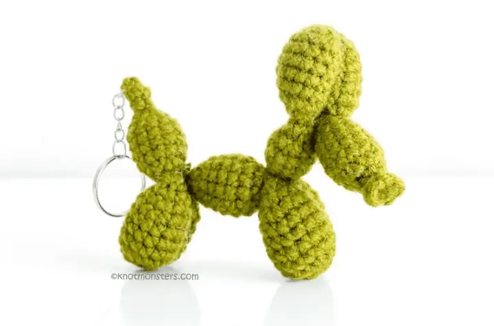 Green crochet keychain that looks like a balloon dog.
