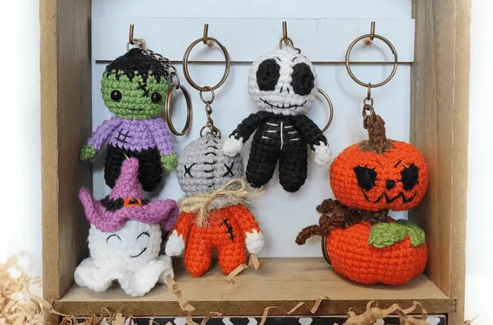 Halloween-themed keychains feautruing a ghost keychain, pumpkin, jack-o-latern, skeleton, frankenstein, and scarecrow.