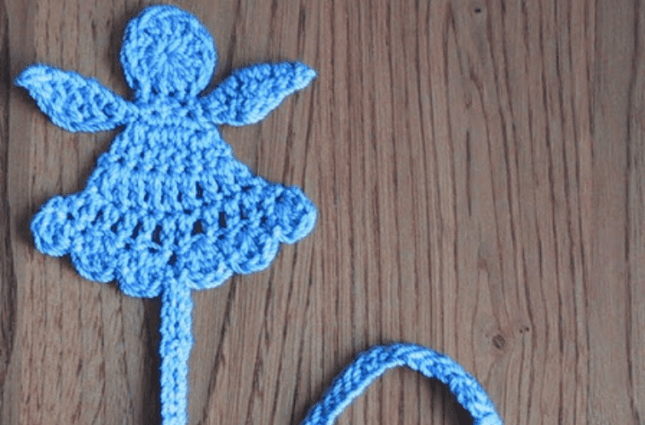Crochet angel bookmark with blue yarn.