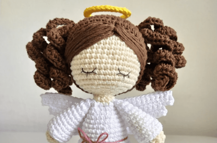A brunette crochet angel wearing curly pigtails.