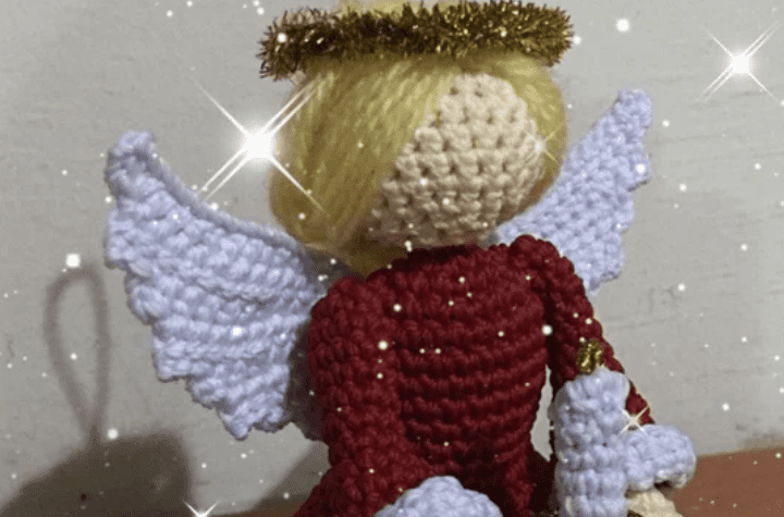 A blonde crochet angel wearing a red dress.