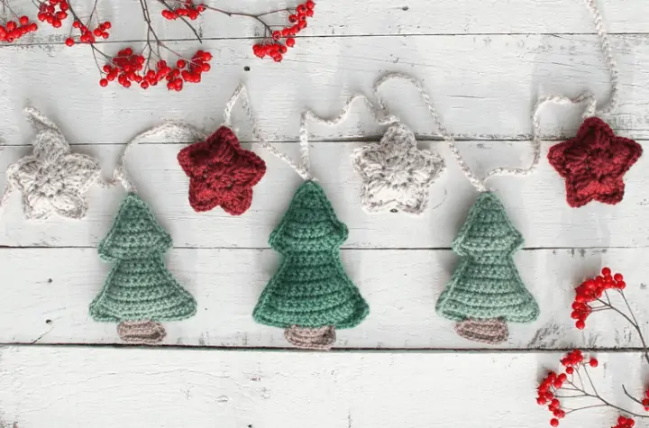 Crochet Christmas trees and small starts strung together on a garland.