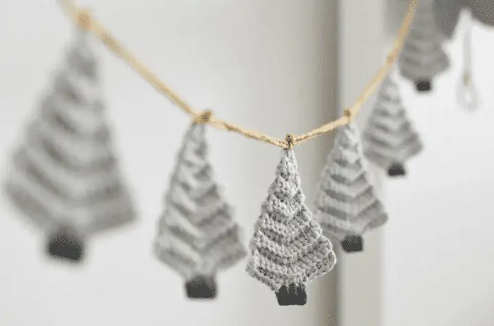 Grey crochet Christmas trees strung together on a garland.