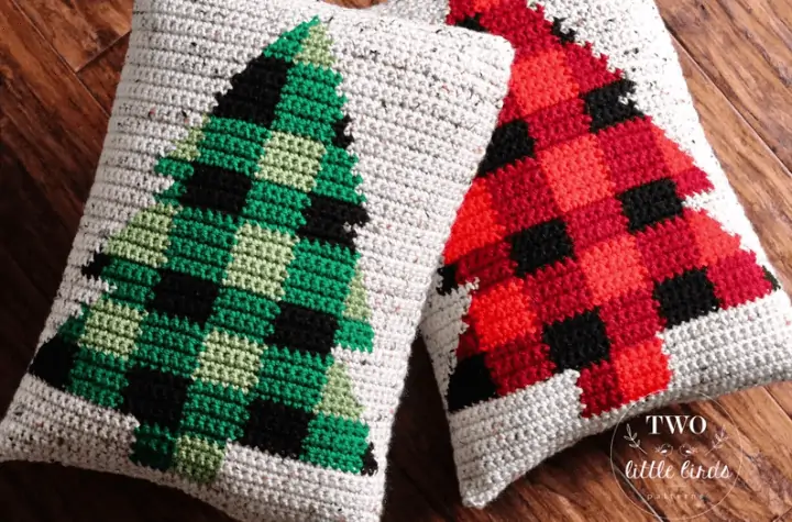 Two pillows, one with a green plaid Christmas tree on it and one with a red plaid Christmas tree on it.