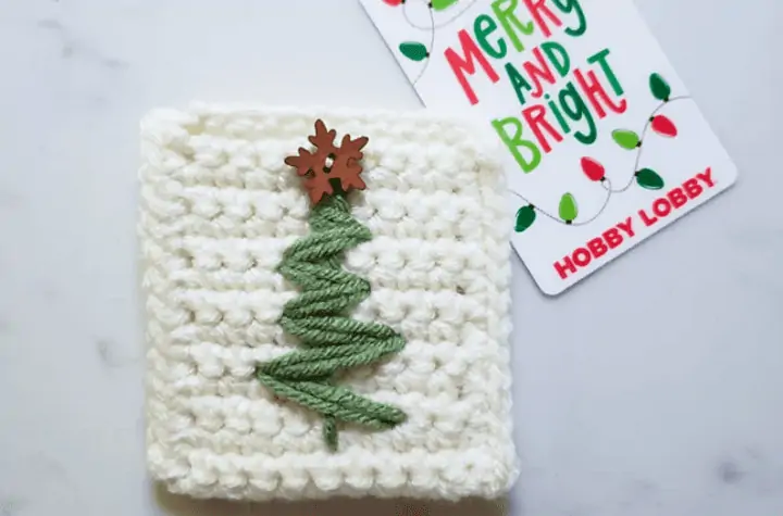 White square with a minimalist Christmas tree on it that features a snowflake button as the star topper