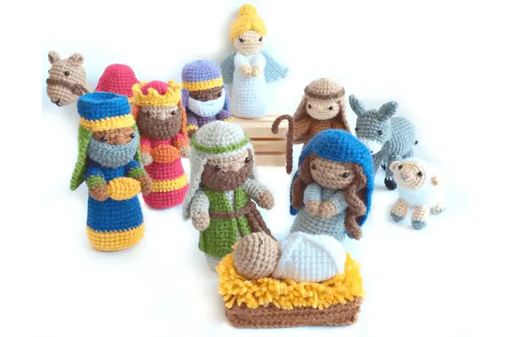 Full amigurumi nativity scene with the holy family, three wise men, a camel, an angel, a shepard, a donkey, and a sheep.