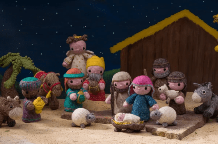Full amigurumi nativity scene complete with the holy family, three wise men, an angel, a few sheep, a cow, a camel, and a donkey.