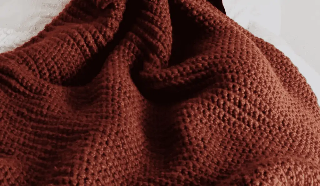 A brown-orange crochet blanket that looks like it's all using the same stitch.