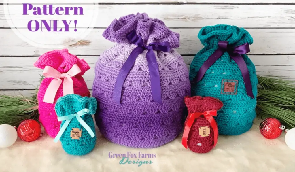 Five crochet gift bags that look likw little sacks with bows on them. One is pink, one is ombre purple, one is large blue, then small blue, then small red.