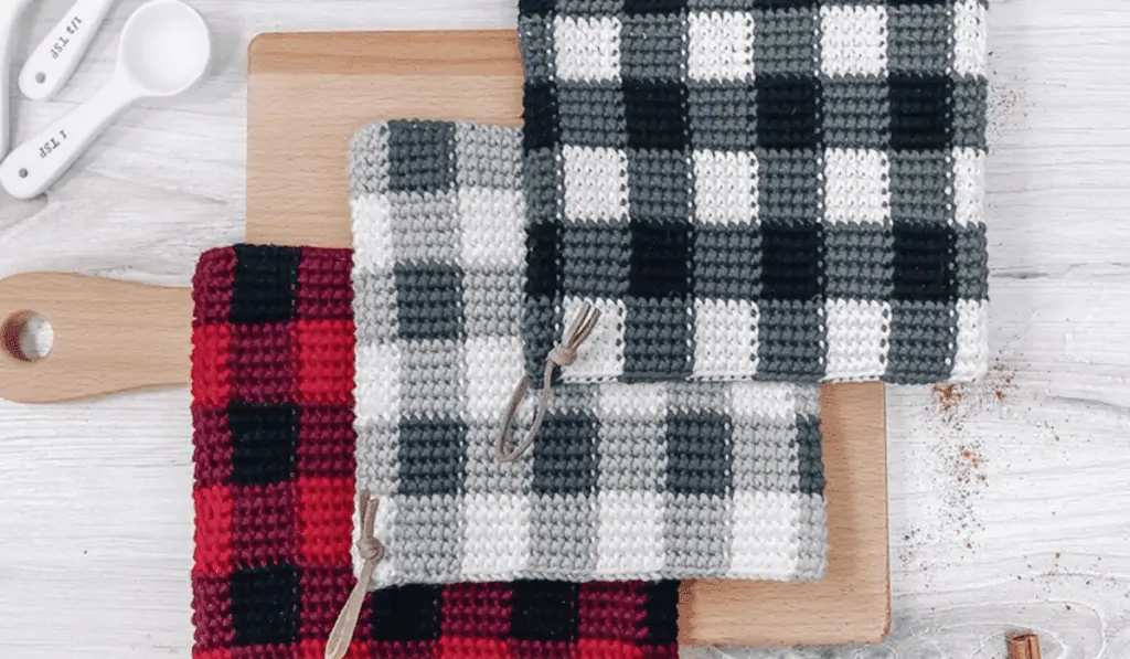 Three crochet pot holders in different versions of buffalo check print.