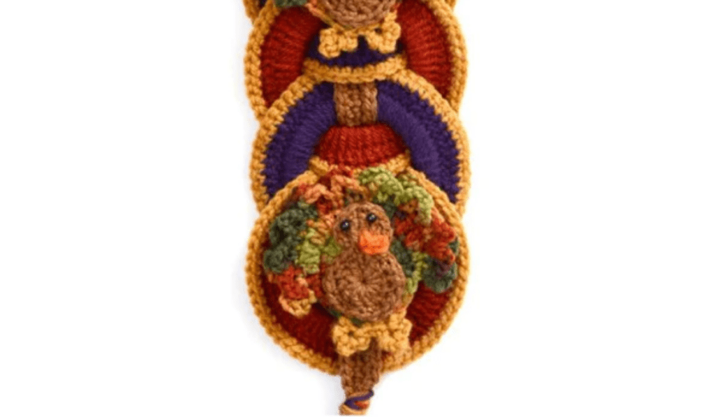 A long door hanging crochet turkey with turkeys in different colored circles.