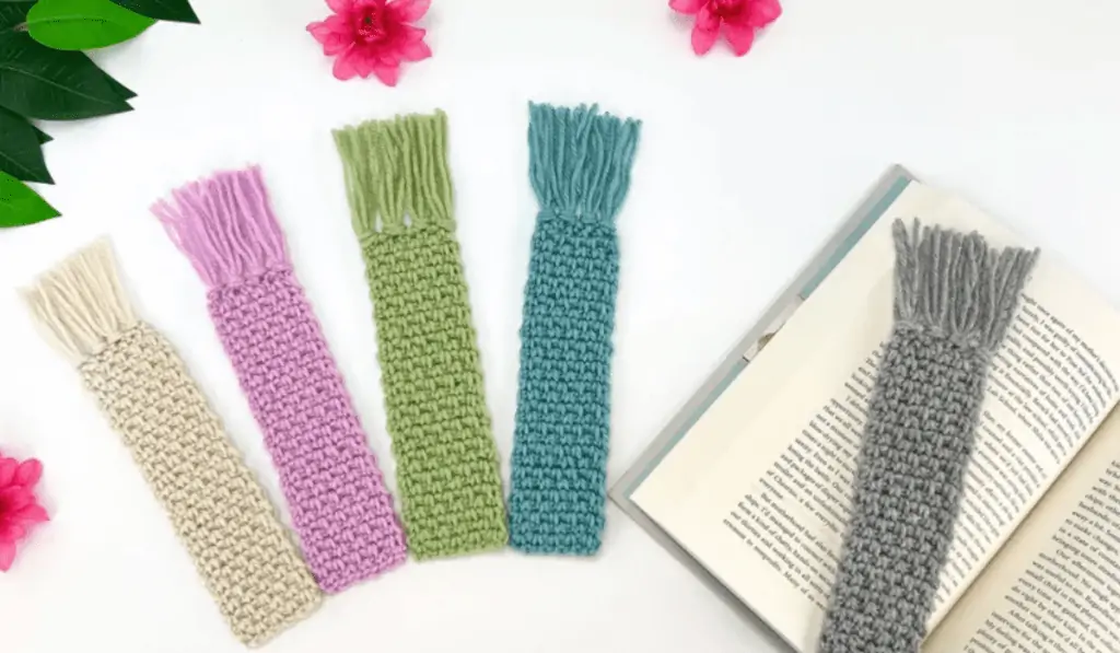 Five crochet bookmarks, one is white, one is pink, one is green, one is blue, and one is grey.