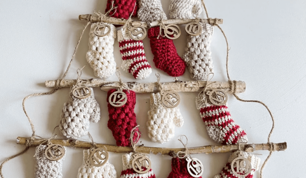 Multiple rows of branches with stocking and mitton ornaments hanging off of it to make it look like a tree.