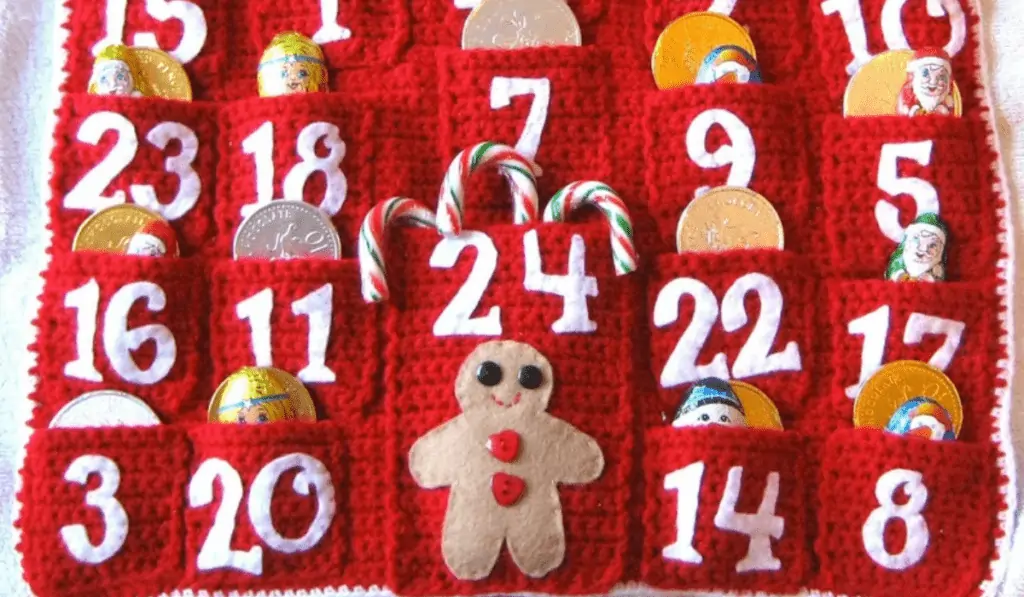 An all red crochet advent calendar with a gingerbread on the pocket for the 24th.