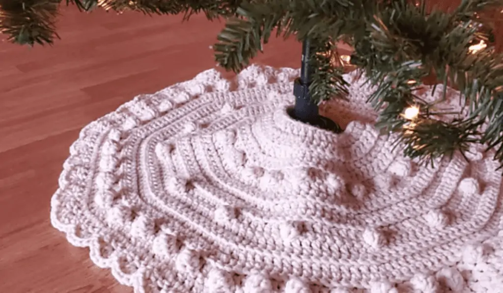 A whgite tree skirt with circular stitches within the skirt.