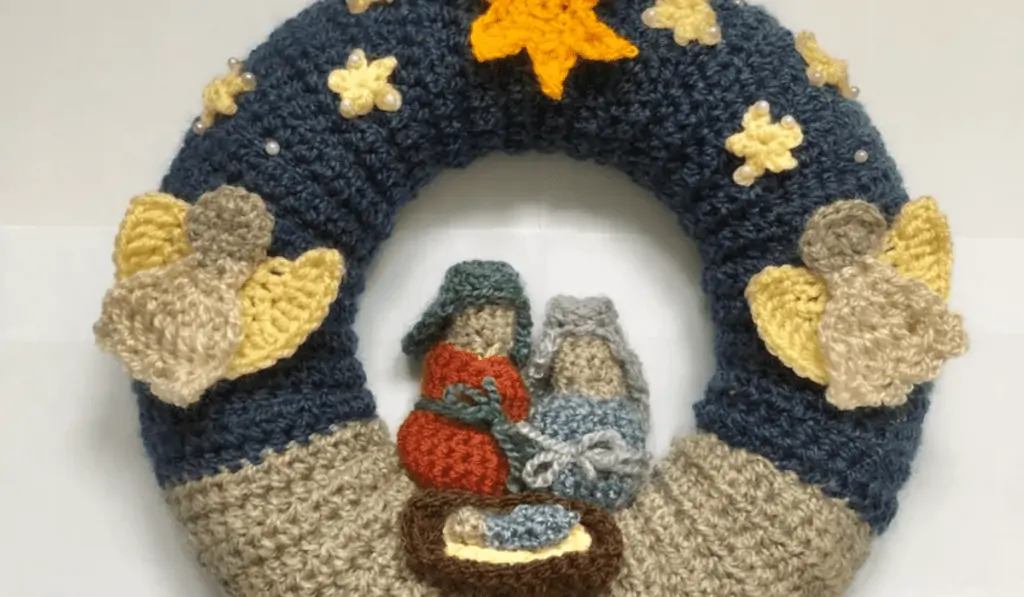 a crochet nativity scene featuring the holy family and two angels.