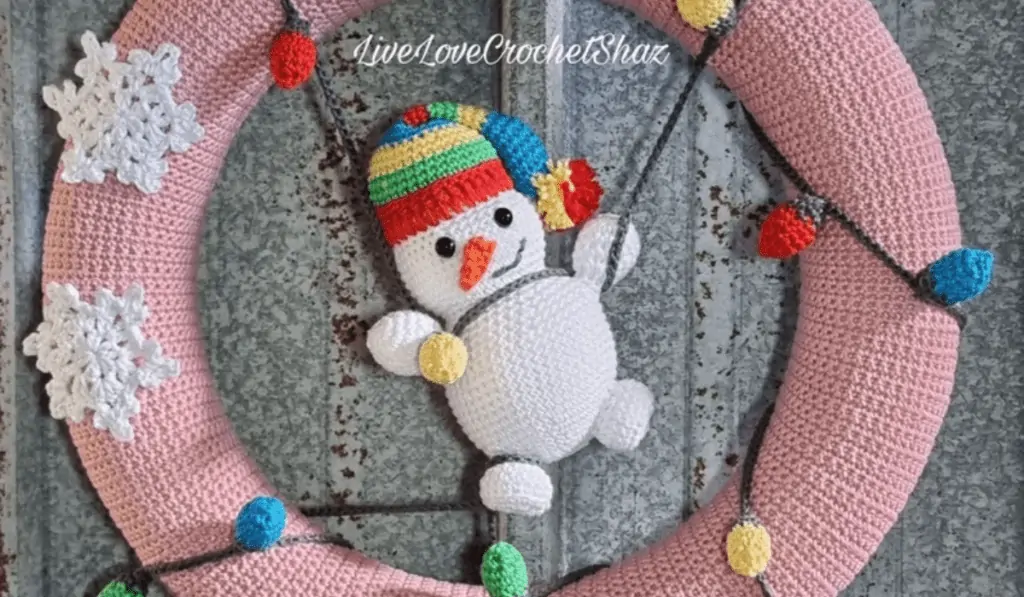 A beige crochet wreath, snowflakes, and a snowman tangeled in Christmas lights.