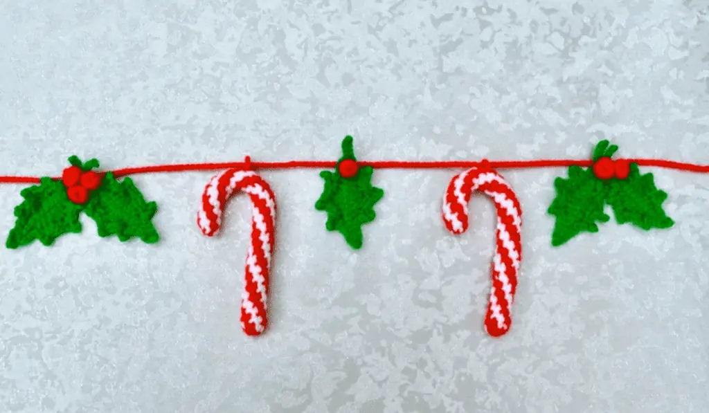 A crochet garland with candy canes and hollys.
