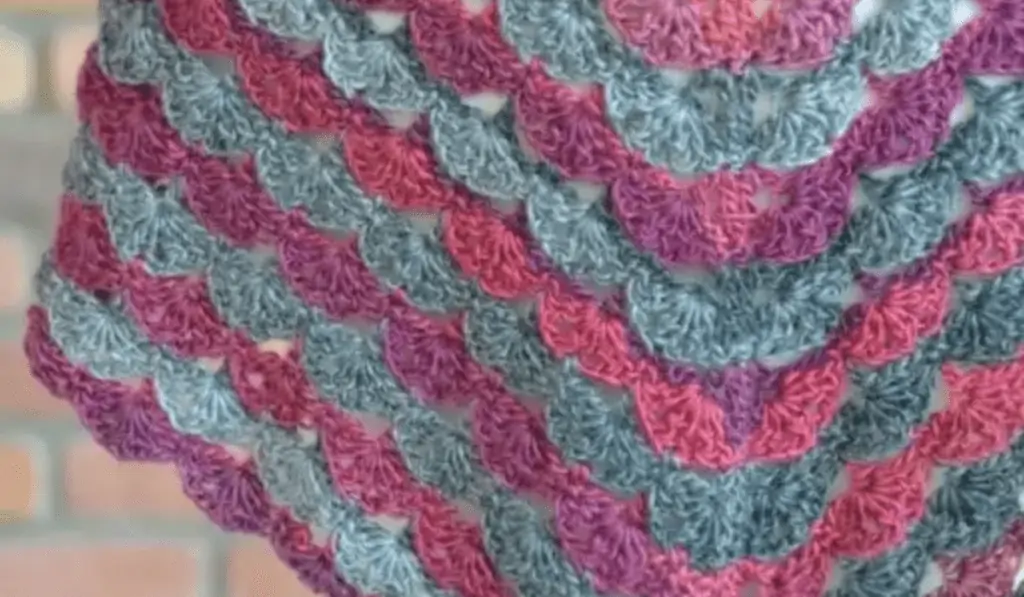 Purple, blue, and pink half-circle stitches on a shawl.
